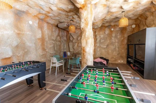 Foosball and air hockey tables in the cave-themed games room